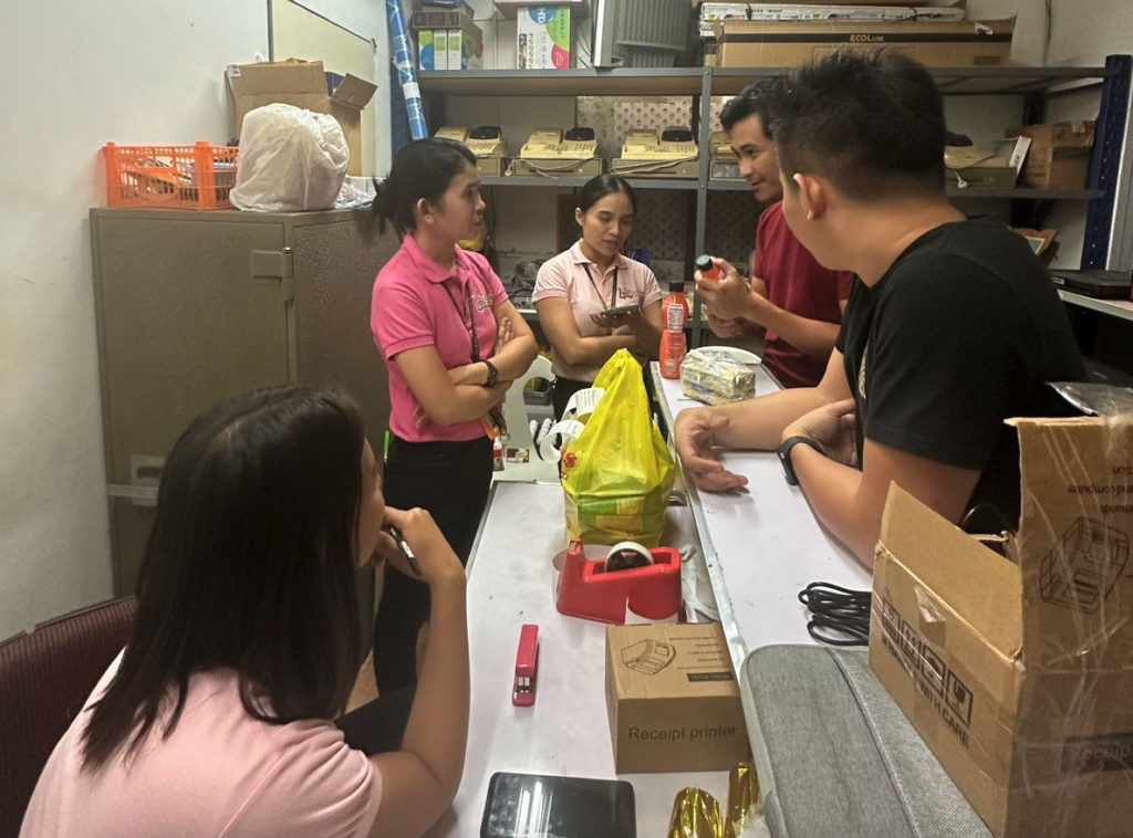 The yufin team talking to the Lots for Less staff inside their warehouse.