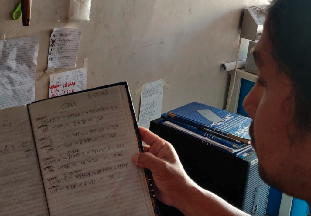 A yufin user holding a notebook he uses to record and collect monthly rent from his tenants.