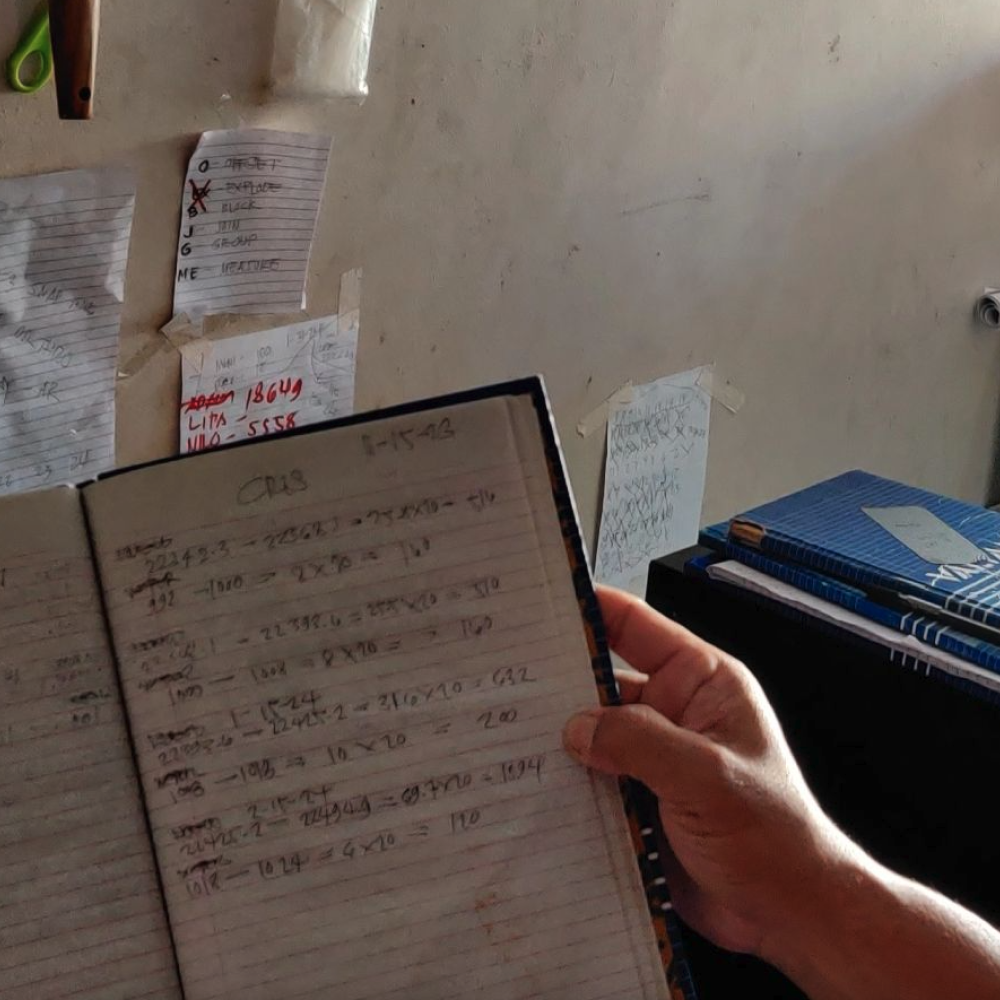 A yufin user holding a notebook he uses to record and collect monthly rent from his tenants.