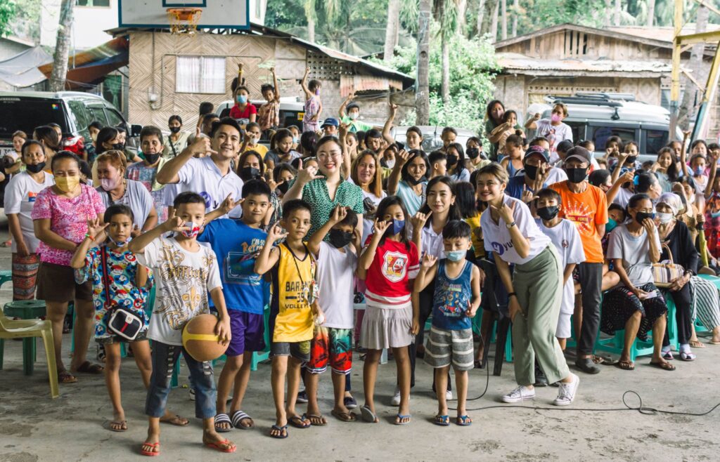 The yufin team with a group of people making the yufin symbol with their hands.