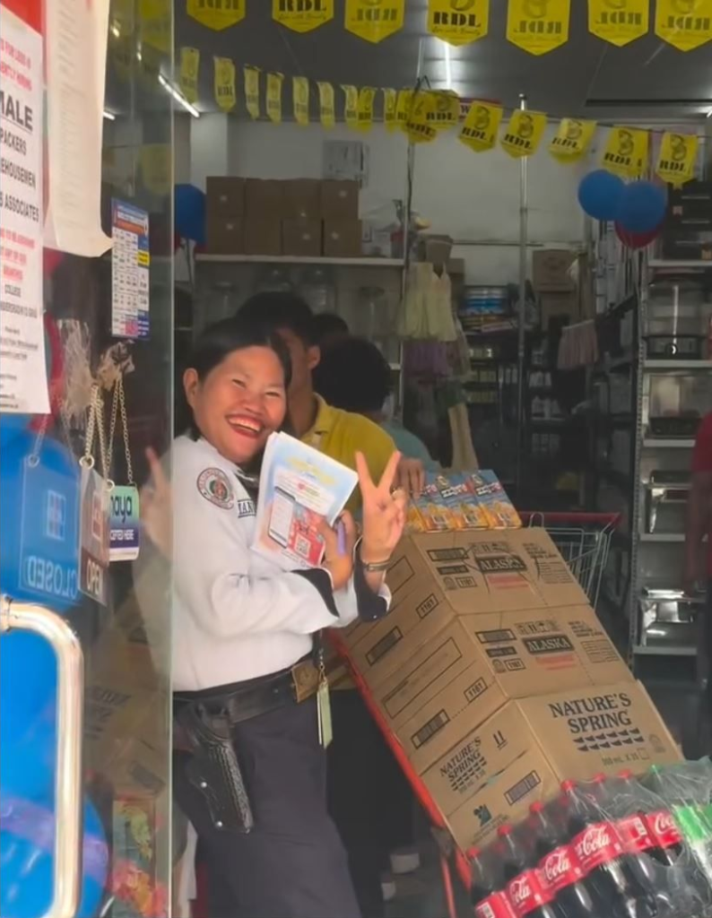 Lots for Less security guard poses in front of the camera holding yufin flyers