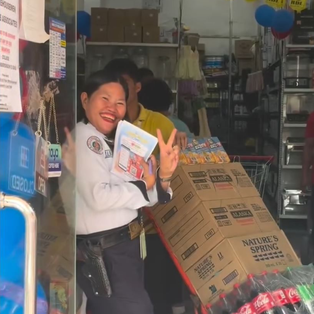 Lots for Less security guard poses in front of the camera holding yufin flyers