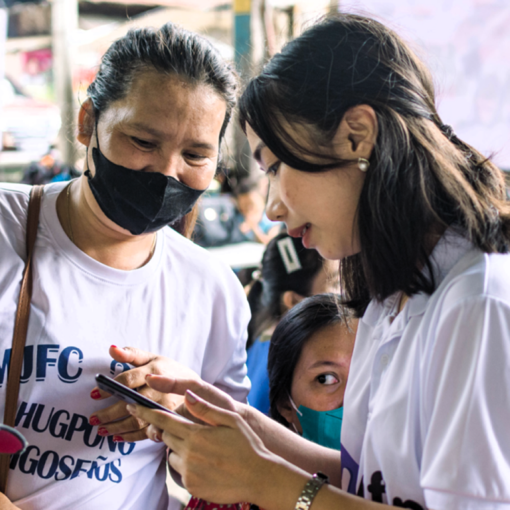 A yufin employee together with a yufin merchant looking at a smartphone.