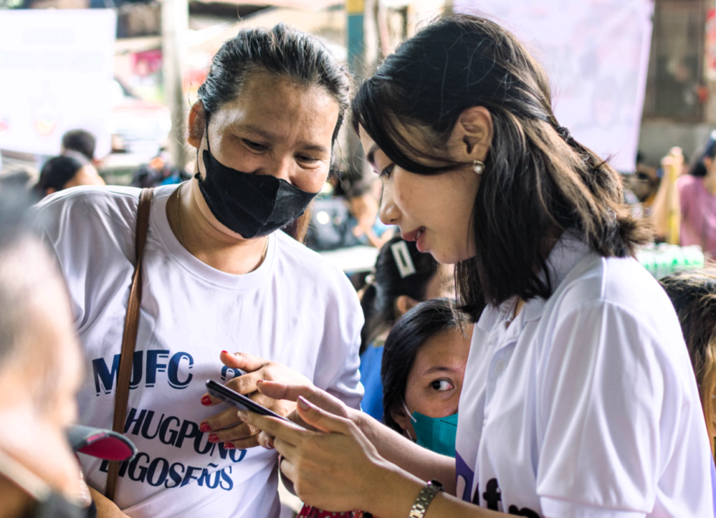 A yufin employee together with a yufin merchant looking at a smartphone.