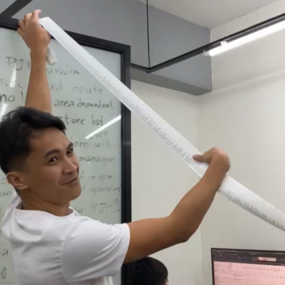 A yufin employee showing the camera the long receipt.