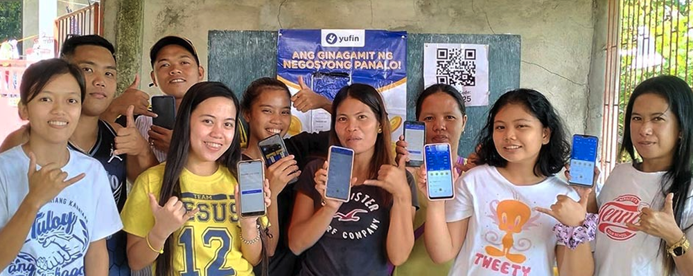 yufin merchants showing the yufin app on their smartphones.