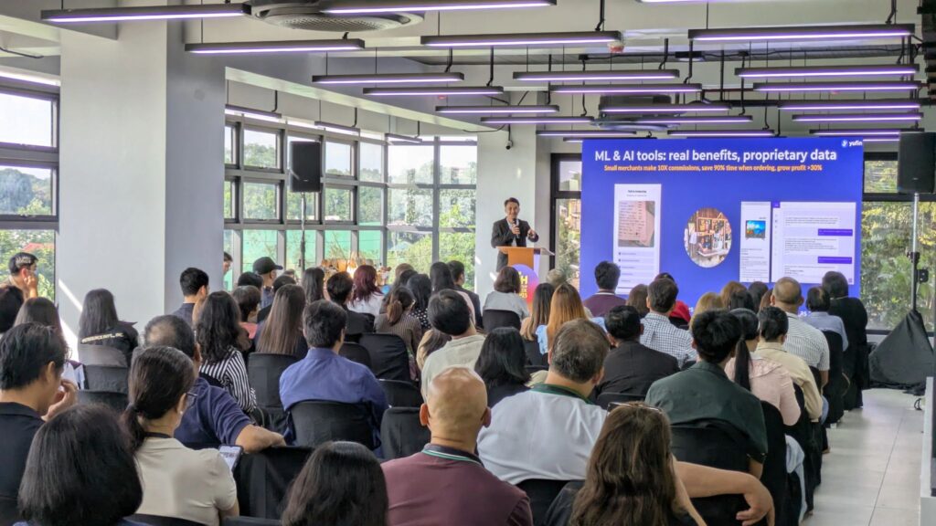 A yufin employee presenting on stage at the event.