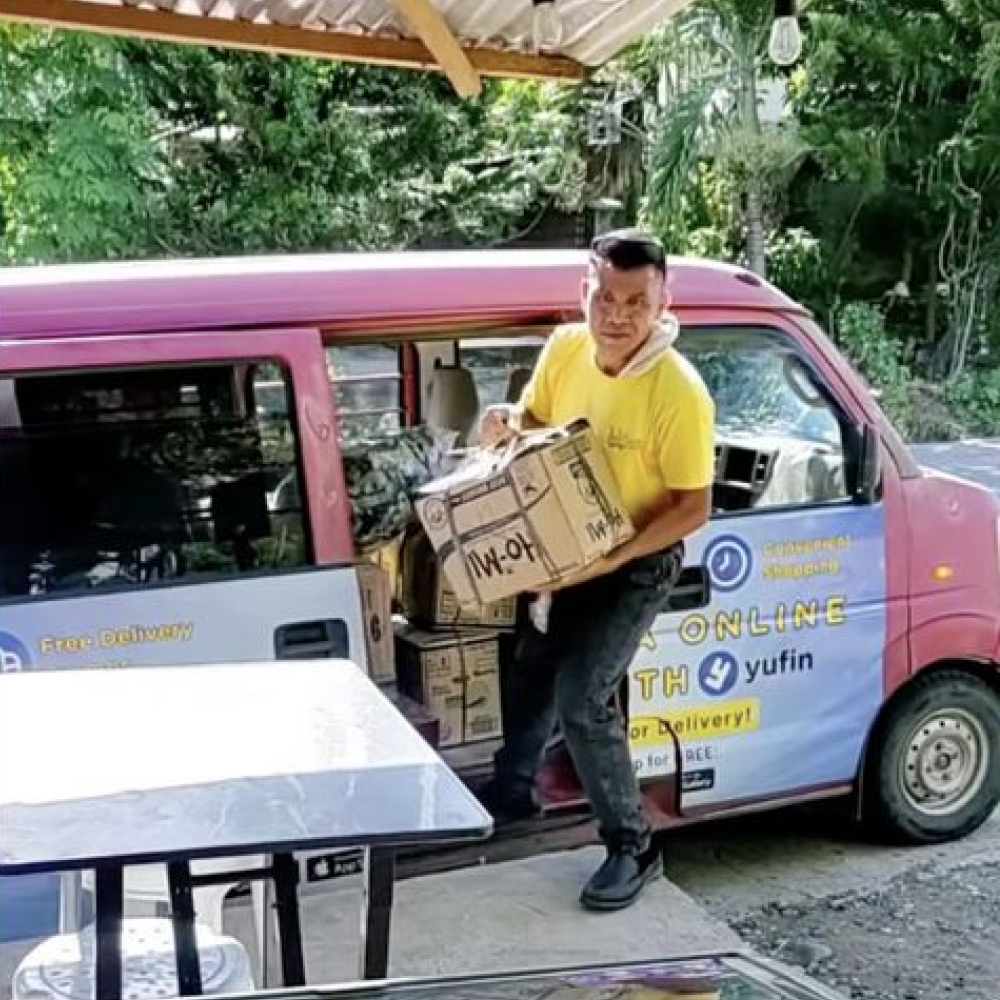 Lots for Less staff carrying a box for delivery.